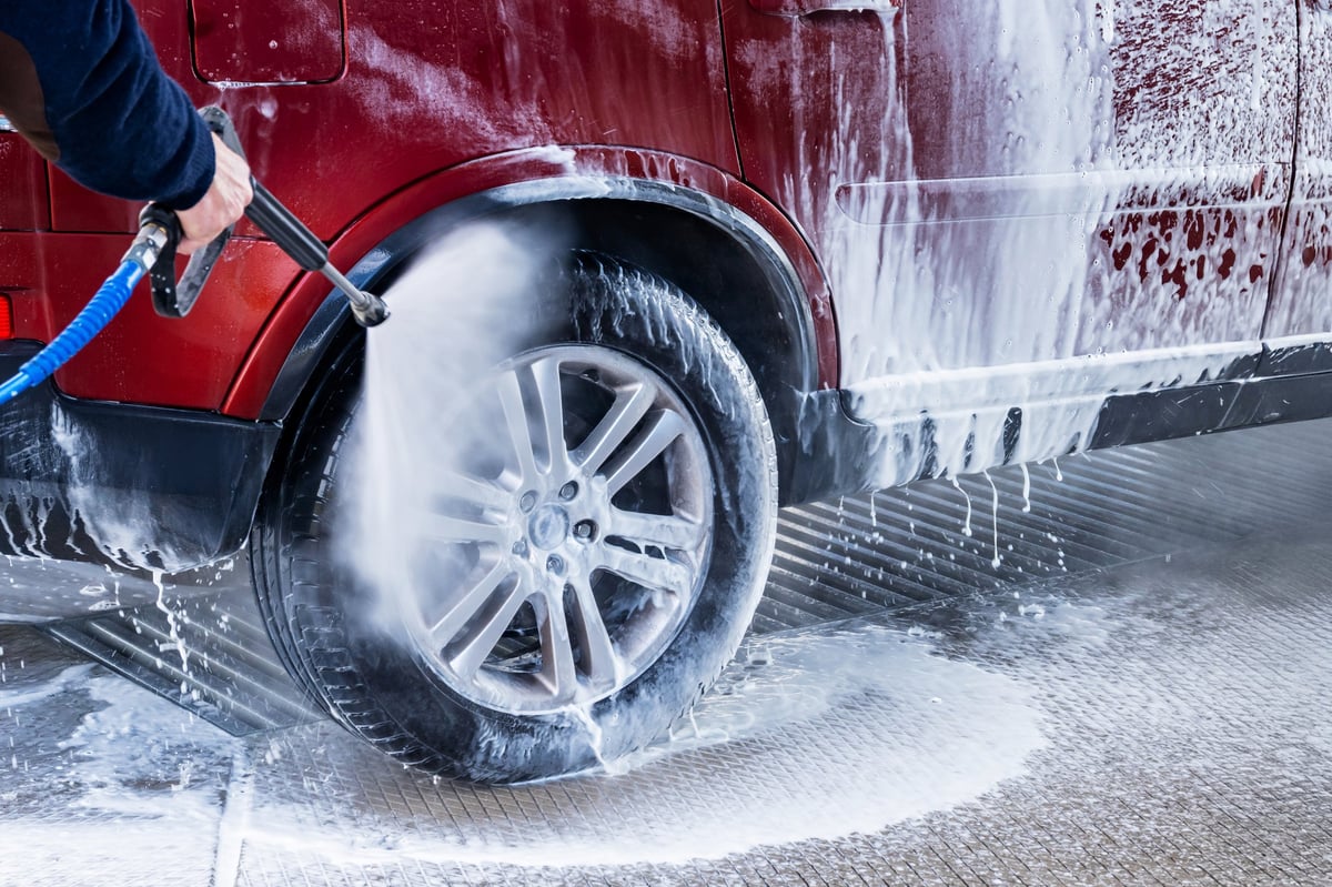 Lavaggio esterno: auto rossa coperta di schiuma